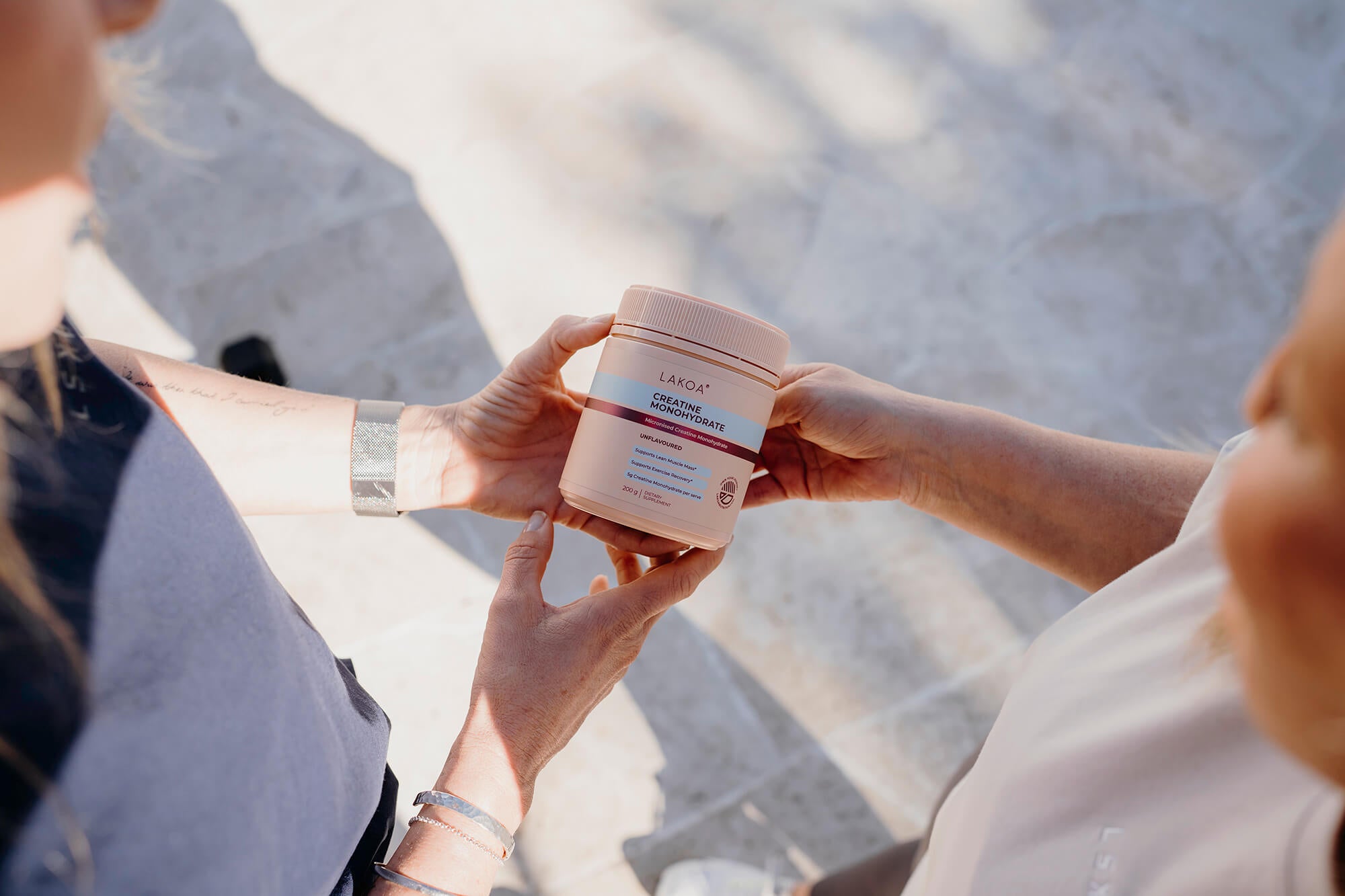 Two women holding creatine monohydrate
